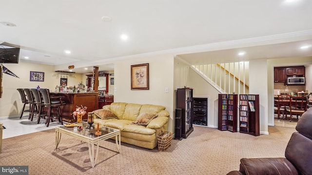 living room featuring crown molding, bar area, and light colored carpet