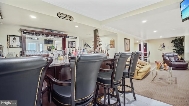 bar with crown molding and light tile patterned flooring