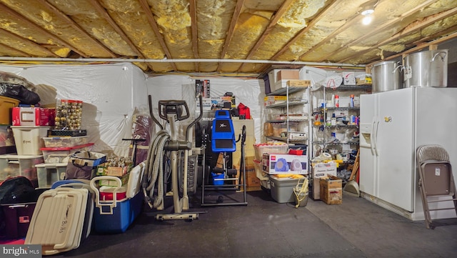 basement with white refrigerator with ice dispenser