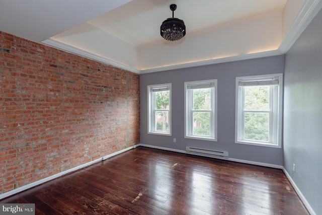 empty room featuring brick wall, dark hardwood / wood-style floors, a baseboard heating unit, and a wealth of natural light