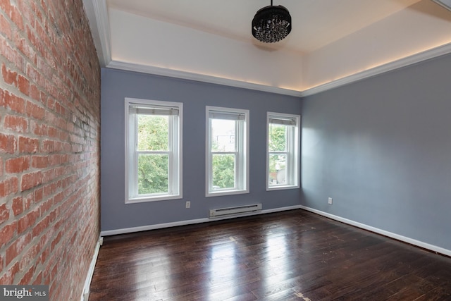 empty room featuring brick wall, ornamental molding, dark wood-type flooring, and a baseboard heating unit