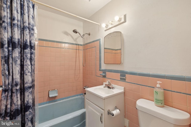 full bathroom featuring tile walls, shower / tub combo, vanity, and toilet