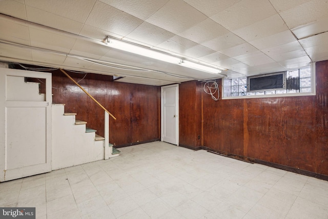 basement featuring wooden walls