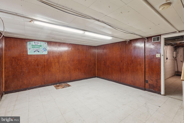 basement featuring wooden walls