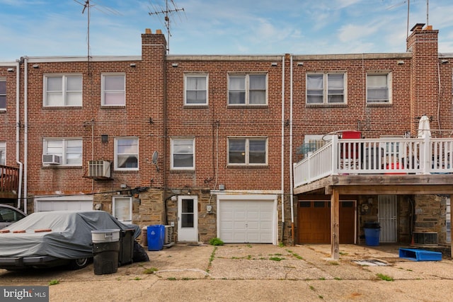 back of house featuring cooling unit, a garage, and a wooden deck