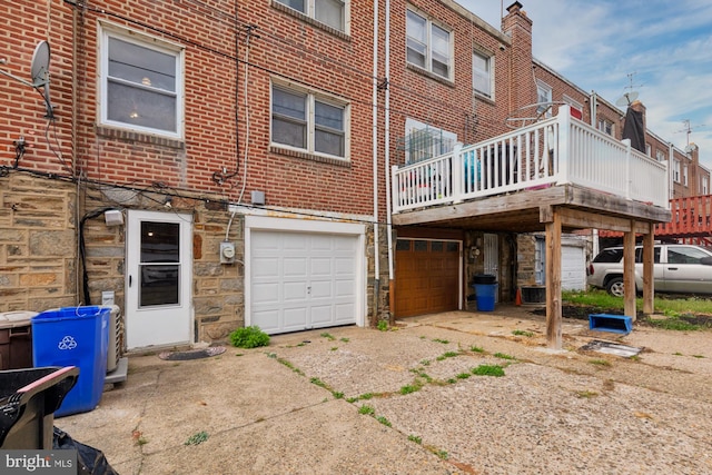 rear view of house featuring central air condition unit, a garage, and a wooden deck