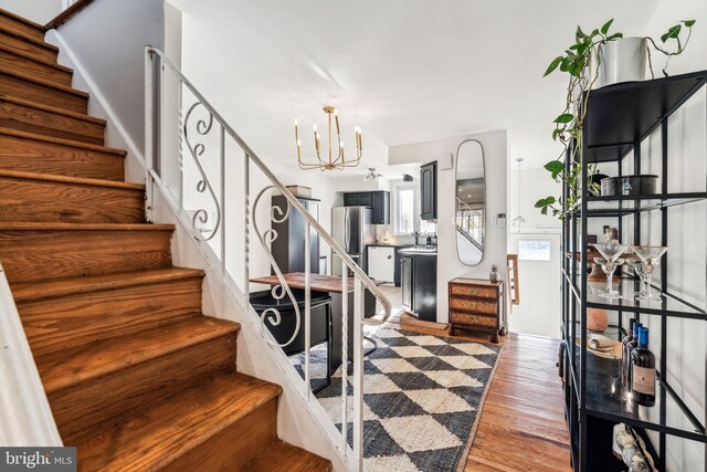 staircase featuring a chandelier and hardwood / wood-style flooring