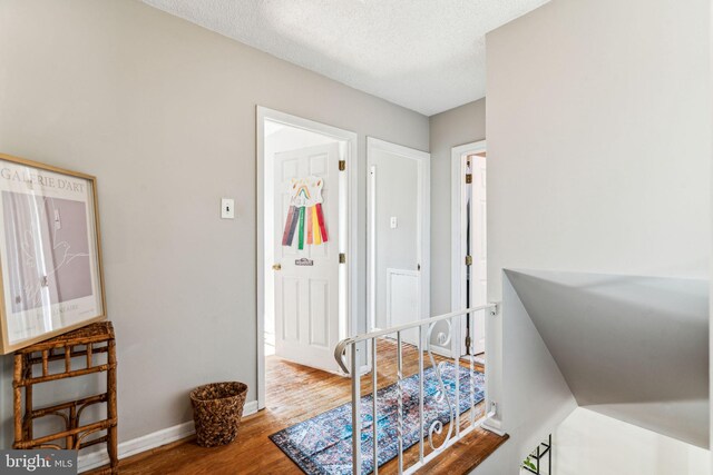 hall featuring hardwood / wood-style floors and a textured ceiling