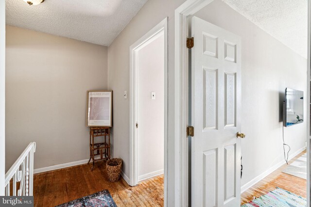 hall featuring a textured ceiling and light wood-type flooring