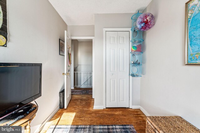 interior space featuring a textured ceiling and dark hardwood / wood-style flooring