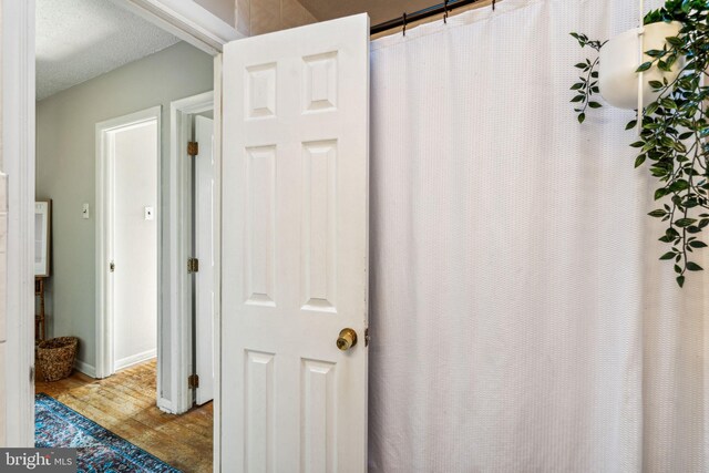 bathroom with hardwood / wood-style flooring and a textured ceiling