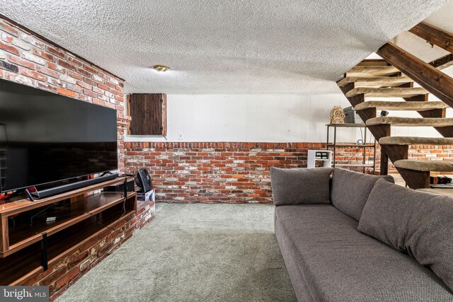 living room featuring brick wall, a textured ceiling, and carpet floors