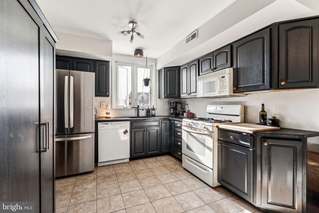 kitchen with sink, white appliances, and light tile patterned floors