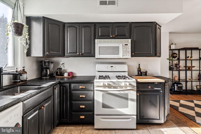 kitchen with sink, light wood-type flooring, and white appliances