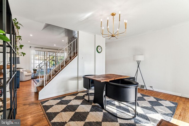 dining space with hardwood / wood-style flooring and an inviting chandelier