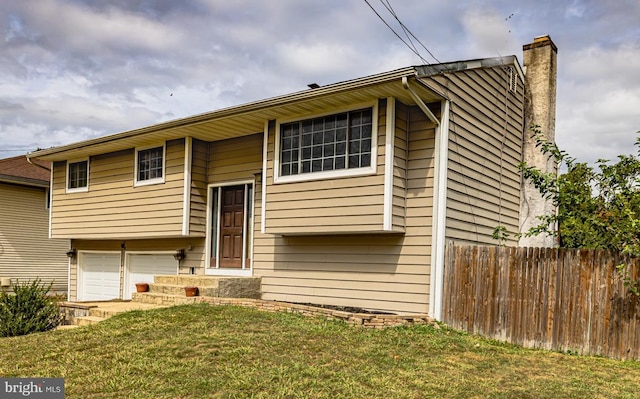 bi-level home featuring a garage and a front yard