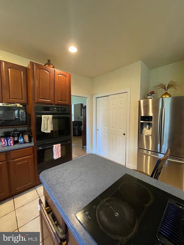 kitchen featuring black appliances and light tile patterned floors