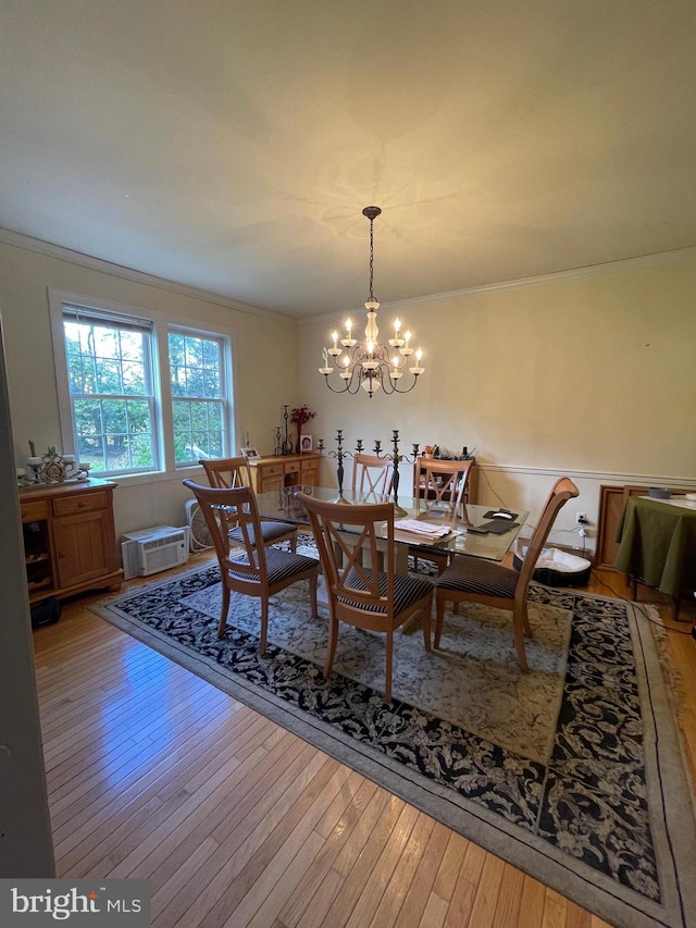 dining space with a notable chandelier, hardwood / wood-style floors, and crown molding