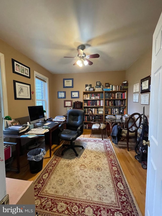 home office featuring hardwood / wood-style floors and ceiling fan