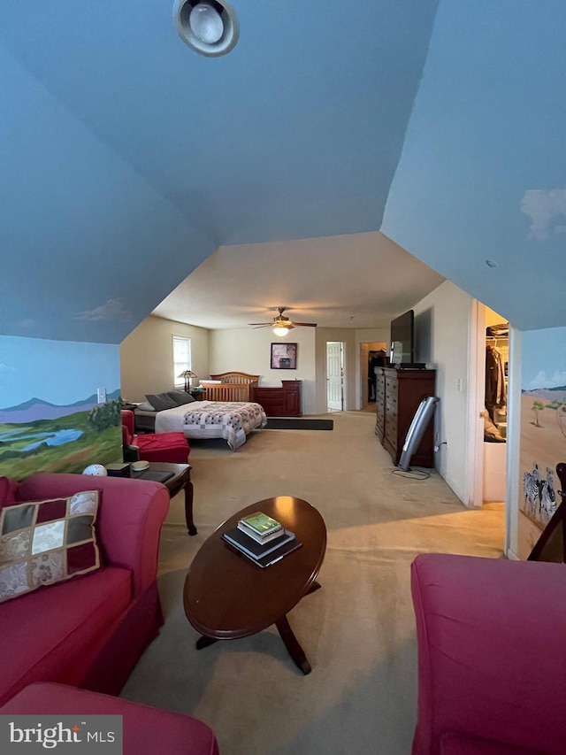 bedroom featuring lofted ceiling, light carpet, and a walk in closet