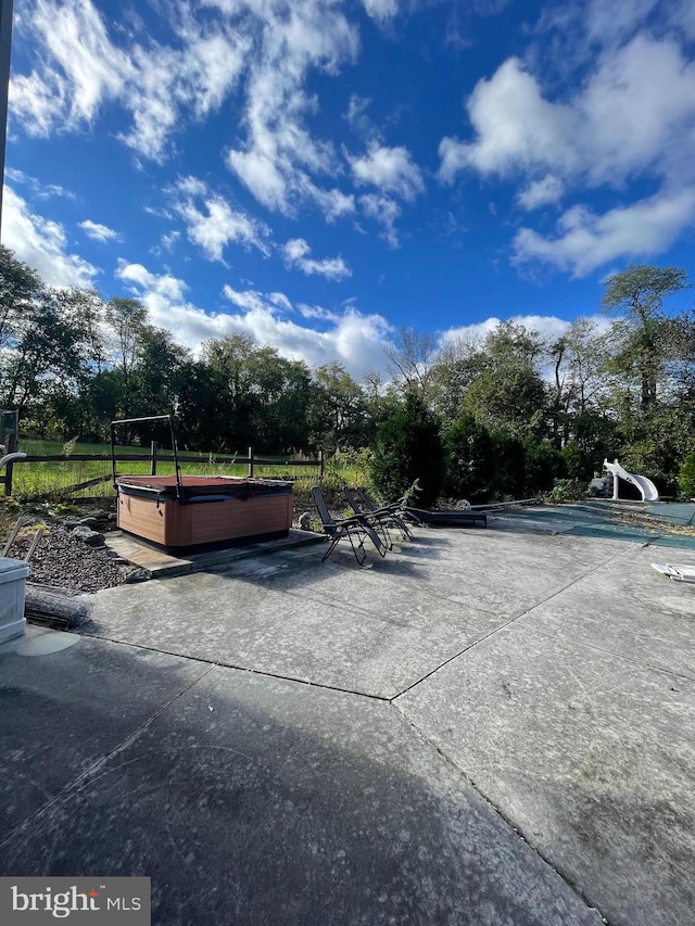 view of home's community with a patio area and a pool with hot tub