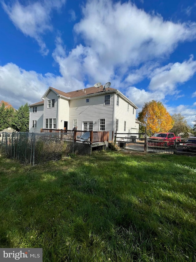 rear view of property with a yard and a wooden deck