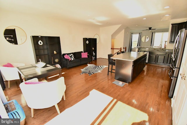 living room with light hardwood / wood-style floors, sink, and ceiling fan