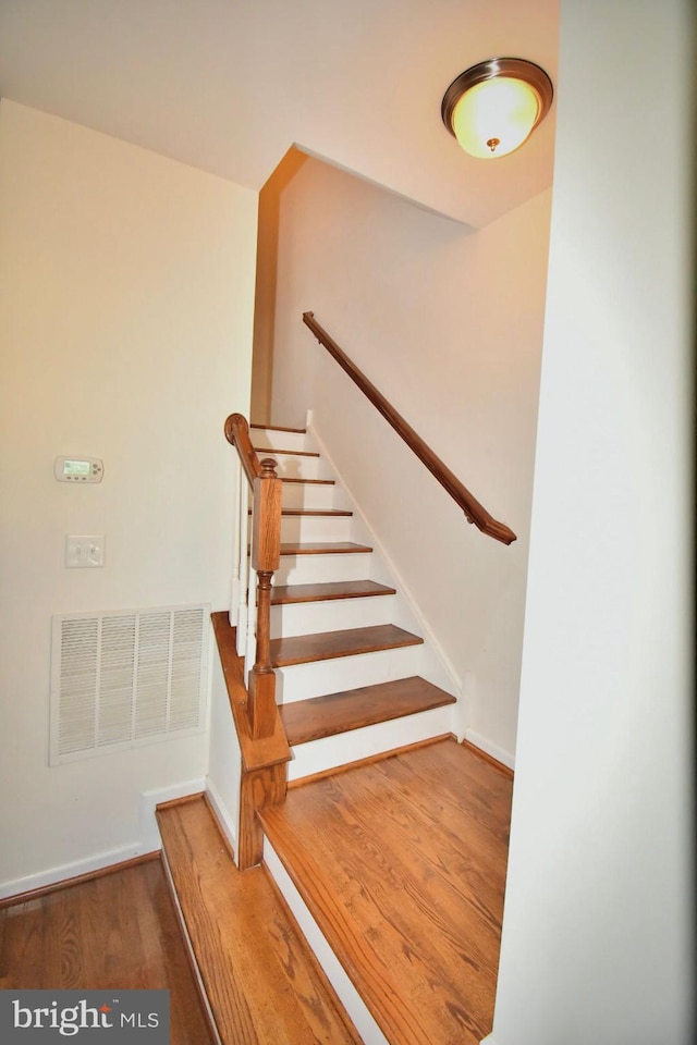 staircase with hardwood / wood-style floors