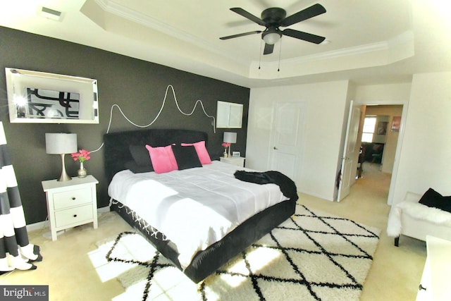 carpeted bedroom with crown molding, ceiling fan, and a raised ceiling