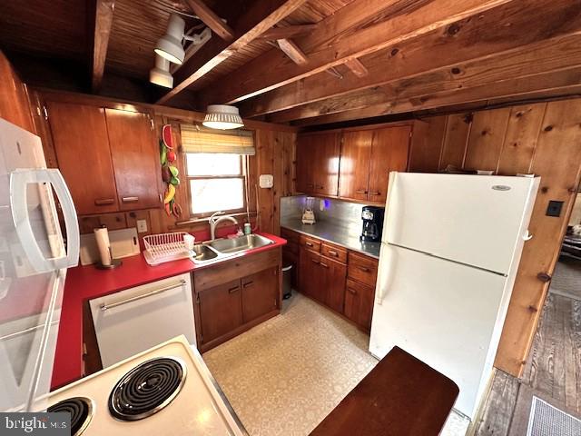 kitchen with light hardwood / wood-style flooring, white appliances, sink, and wooden walls