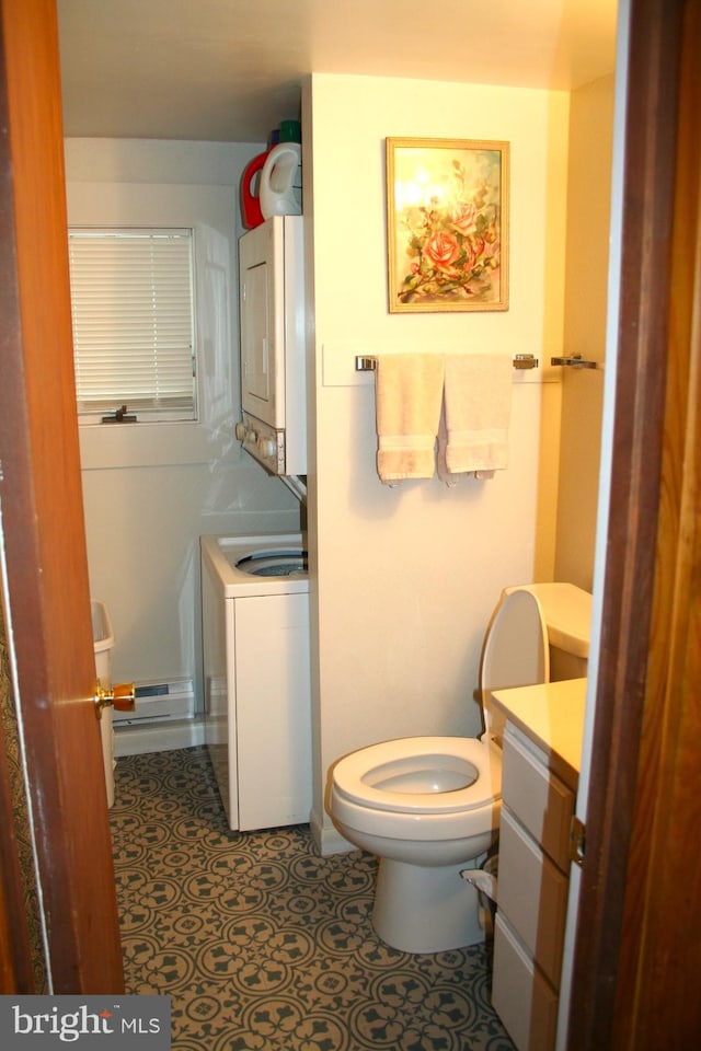 bathroom with stacked washer and dryer, vanity, and toilet