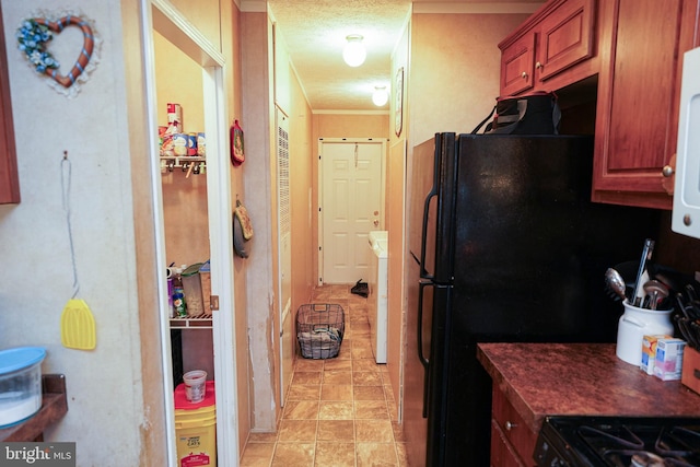 kitchen featuring washer / clothes dryer, a textured ceiling, and crown molding