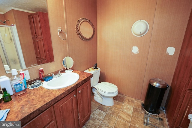 bathroom with a textured ceiling, a shower with shower door, vanity, and toilet