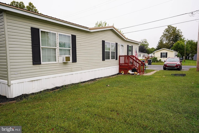 view of side of home featuring cooling unit and a yard