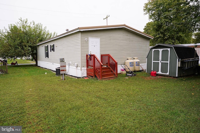 back of property featuring a lawn and a storage shed