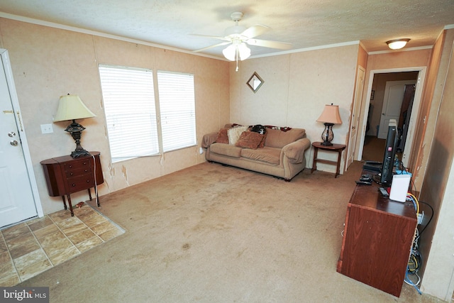 living room with a textured ceiling, ceiling fan, carpet floors, and crown molding