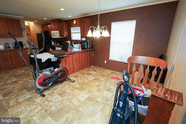 kitchen featuring a notable chandelier, hanging light fixtures, and black refrigerator