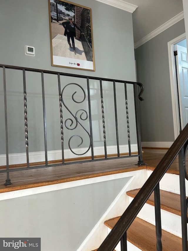 staircase featuring ornamental molding and wood-type flooring