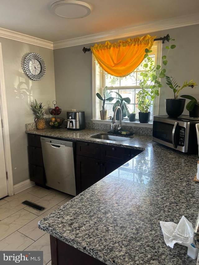 kitchen with appliances with stainless steel finishes, crown molding, and sink