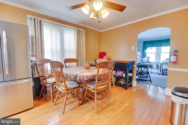 dining room featuring light hardwood / wood-style flooring, ceiling fan, and crown molding