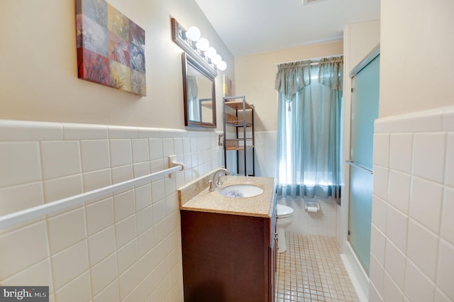 bathroom featuring tile walls, vanity, walk in shower, toilet, and tile patterned floors