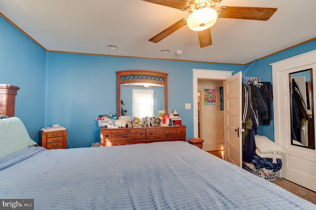 carpeted bedroom with ornamental molding and ceiling fan