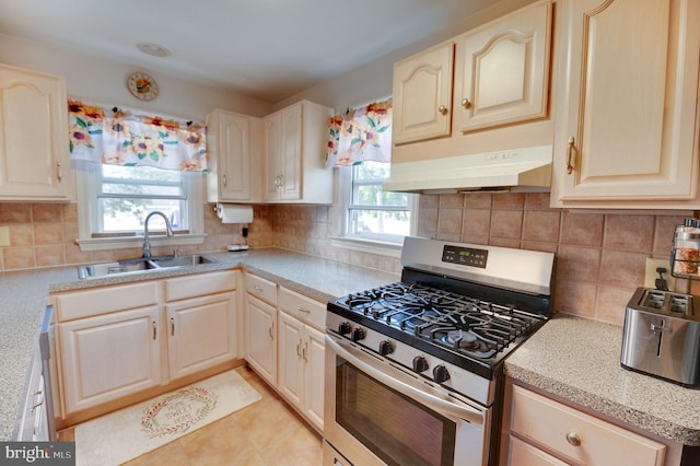 kitchen featuring gas stove, decorative backsplash, and a wealth of natural light