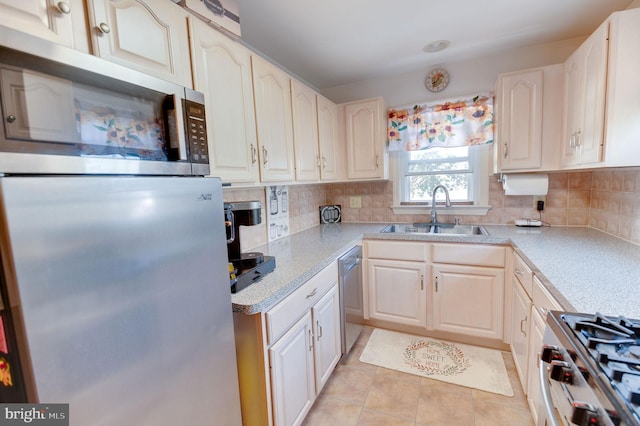 kitchen with decorative backsplash, sink, light tile patterned floors, and stainless steel appliances