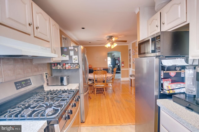 kitchen featuring appliances with stainless steel finishes, light hardwood / wood-style floors, white cabinetry, backsplash, and ceiling fan