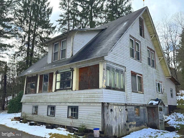 snow covered property featuring a sunroom