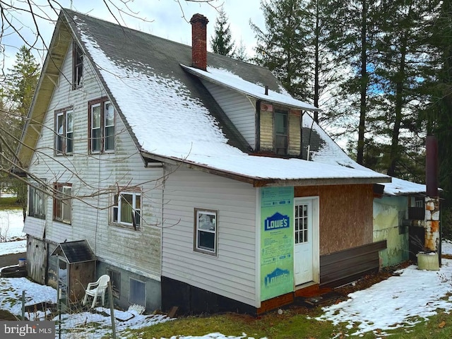 view of snow covered back of property