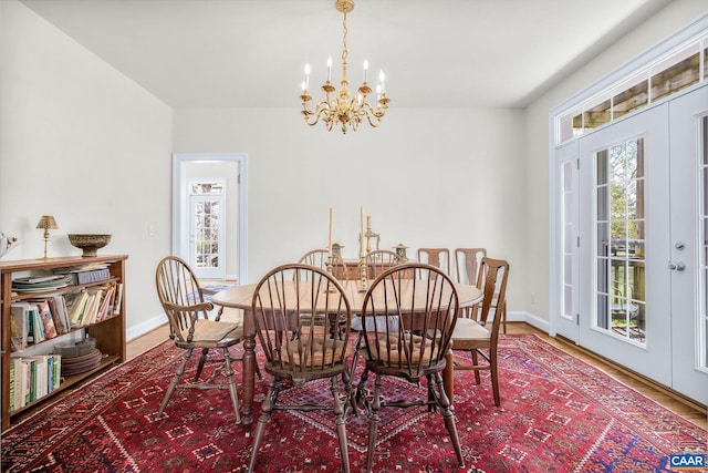 dining area featuring baseboards, an inviting chandelier, wood finished floors, and plenty of natural light