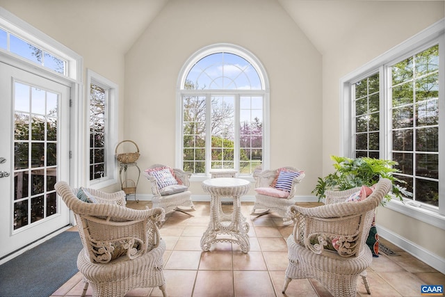 sunroom with tile patterned floors, visible vents, french doors, baseboards, and high vaulted ceiling
