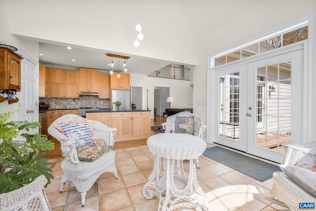 kitchen featuring dark countertops, backsplash, pendant lighting, appliances with stainless steel finishes, and light tile patterned floors